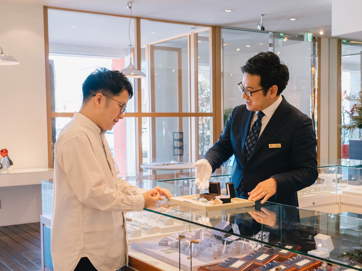 丁寧に案内するヴァニラの販売員と効率的に婚約指輪を検討中の男性