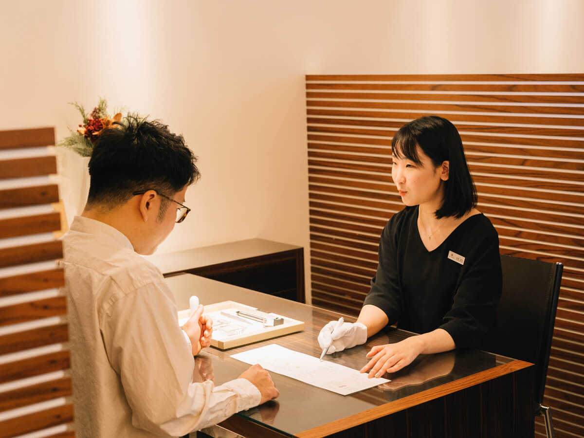 ゆったりとしたプライベート感のある個別ブースで婚約指輪を選ぶ男性