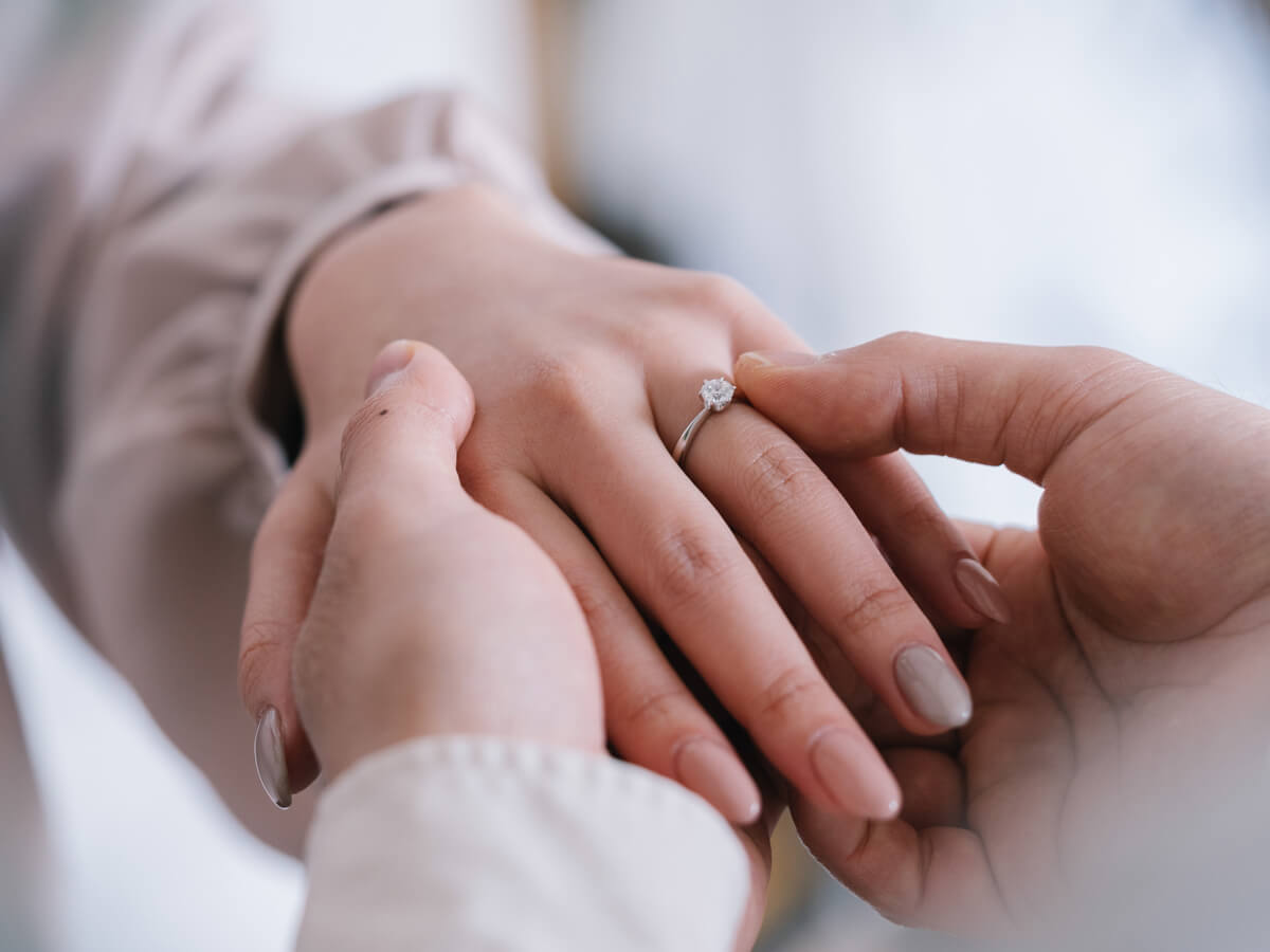 ダイヤモンドが輝く婚約指輪を着用しているカップル