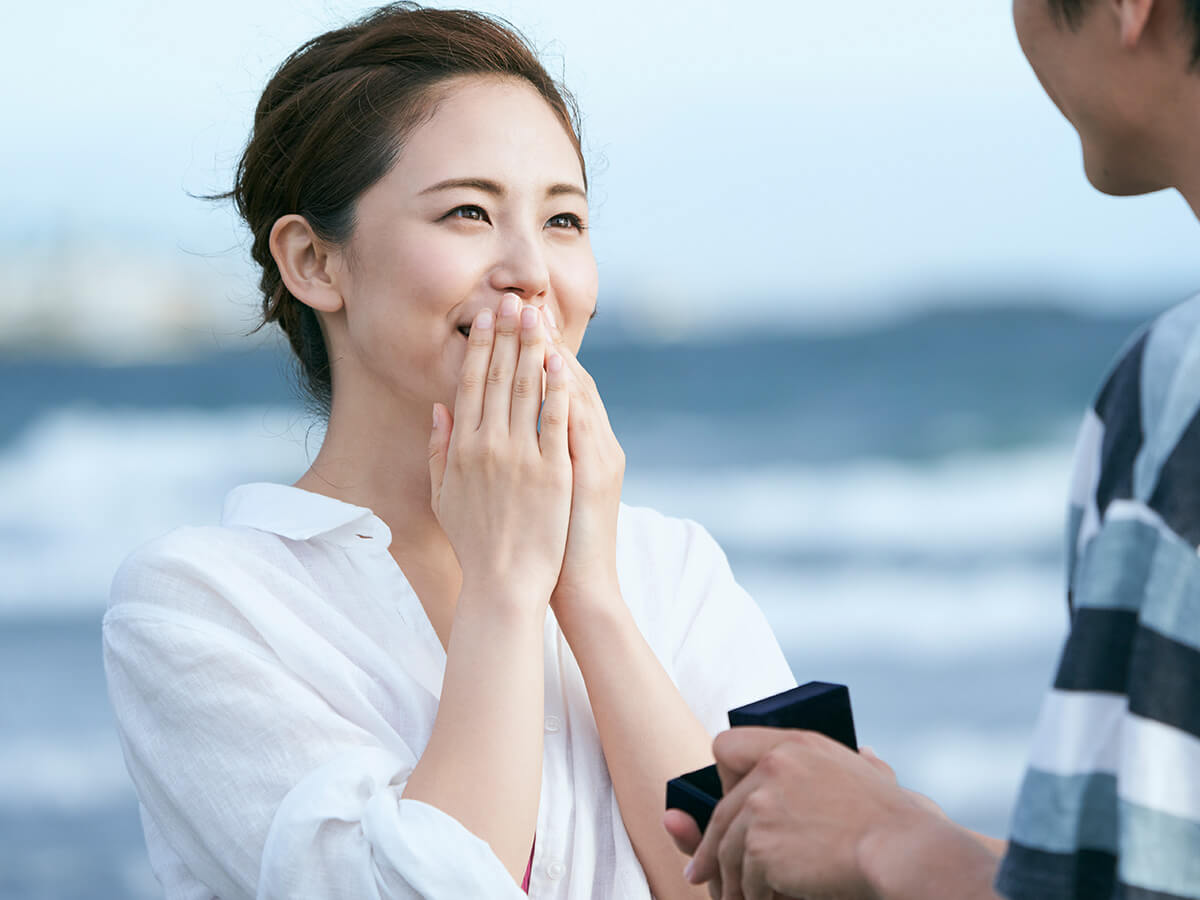 海辺でプロポーズするカップル