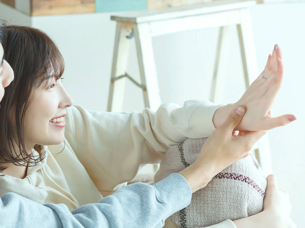 美しい輝きのダイヤモンド婚約指輪を身に着けている笑顔の女性